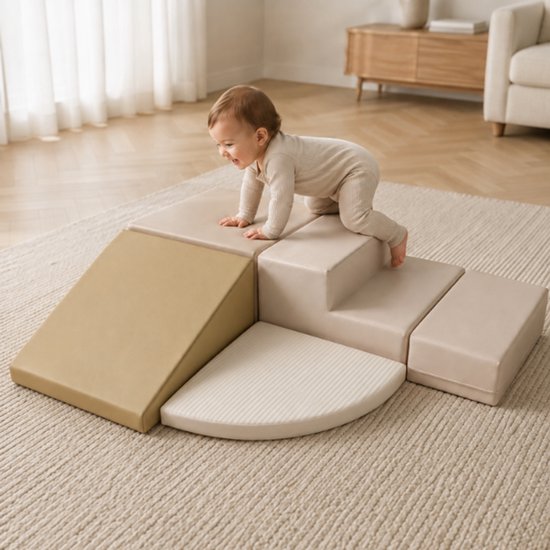 Een baby kruipt op een beige en taupe soft play set met klimschans en trappetjes. De set staat op een gebreid kleed.