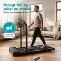Man loopt op een zwarte TibaGoods loopband in de woonkamer met tekst: Draagt 140 kg, zeker en stabiel. Fluisterstille motor.