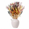 Een boeket droogbloemen in een lichte vaas. Met gedroogde zonnebloemen, gele pluimen en rode bloemaren.
