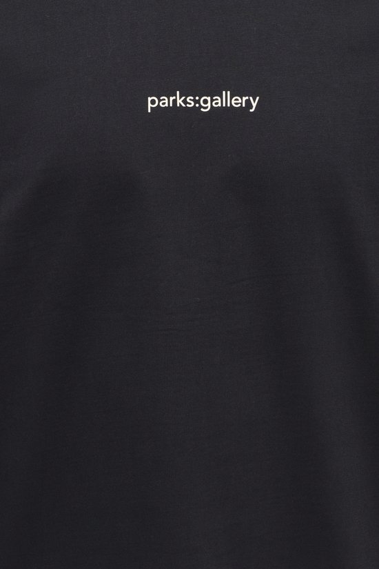 Detail van een zwarte longsleeve met 'parks:gallery' op de borst.
