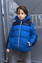 Jongen in een blauw met zwart gewatteerd jack met contourpatroon en capuchon. TYGO & VITO logo op borst.