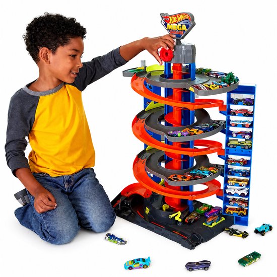Jongen speelt met Mega Garage, 72 cm hoog, inclusief parkeerplaatsen, lift, racebanen en speelgoedauto's.