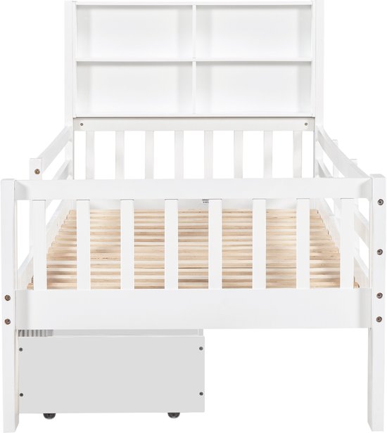 Wit kinderbed met open vakken in het hoofdeinde en een opberglade aan de zijkant.