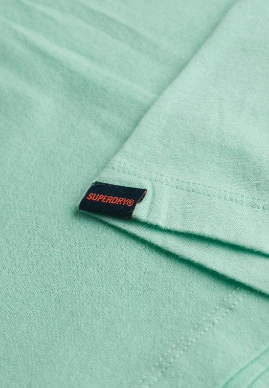 Détail de l'étiquette Superdry sur l'ourlet d'un t-shirt vert menthe.