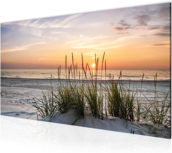 Coucher de soleil sur la mer avec dunes de sable et herbes ondulantes au premier plan.