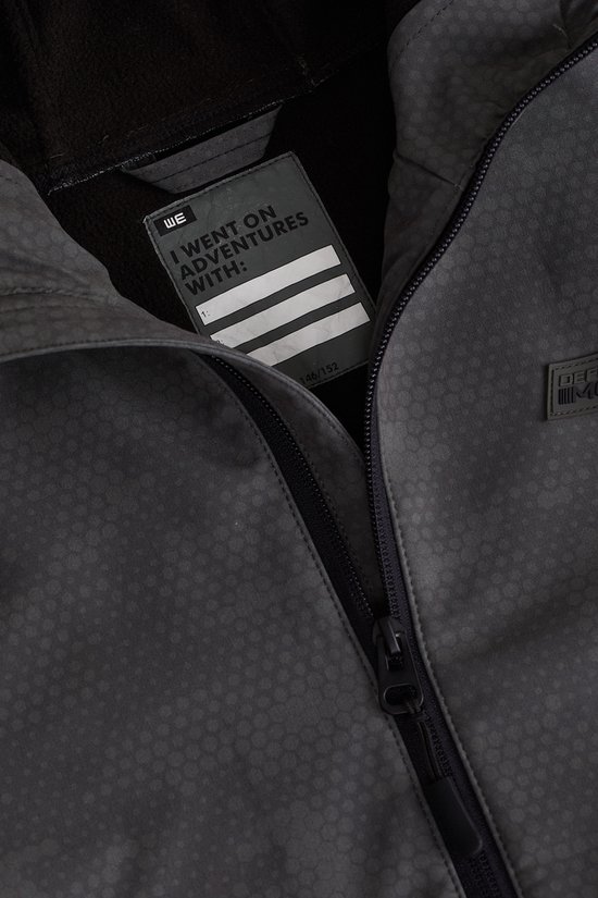 Detail van de binnenkant van een grijze softshell jas met label 'I went on adventures with:'