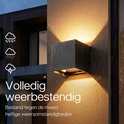 Zwarte kubus buitenlamp op een muur met waterdruppels, 'volledig weerbestendig'.