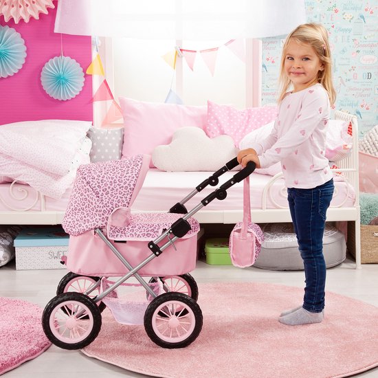 Meisje duwt een roze poppenwagen met luipaardprint in een kinderkamer.