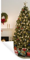 Muurstickers - Sticker Folie - Een kerstboom met cadeautjes naast een open haard - 20x40 cm - Plakfolie - Muurstickers Kinderkamer - Zelfklevend Behang - Zelfklevend behangpapier - Stickerfolie