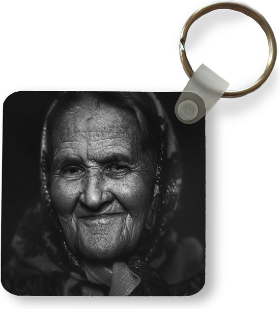 Sleutelhanger - Close up van een oude Kaukasische vrouw haar verweerde gezicht met doek - Plastic - Rond - Uitdeelcadeautjes