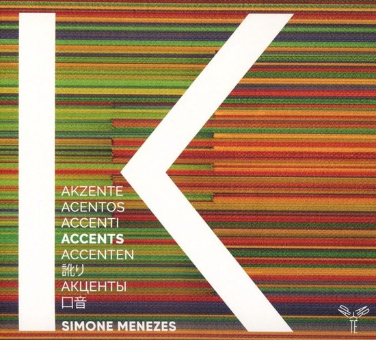 Albumcover met grote witte K op een achtergrond van gekleurde horizontale lijnen in groen, geel, oranje en rood. De tekst 'AKZENTE ACENTOS ACCENTI ACCENTS ACCENTEN 訳り АКЦЕНТЫ 口音 SIMONE MENEZES' is op het midden van de K geplaatst.
