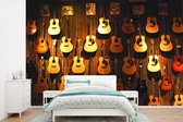 Behang - Fotobehang Veel akoestische gitaren hangen aan een muur - Breedte 360 cm x hoogte 240 cm