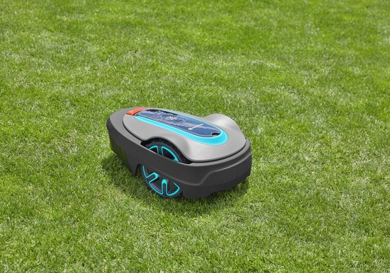 Grijze robotmaaier met blauwe en oranje accenten op een groen gazon.