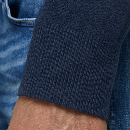 Detail van de mouw van een donkerblauwe trui