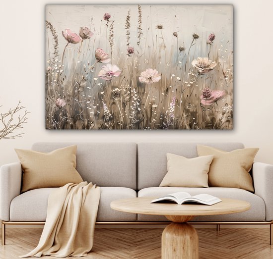 Een schilderij met roze bloemen en grassen op een beige achtergrond, boven een bank.