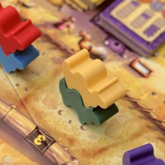 Gekleurde kamelenpionnen gestapeld op een spelbord.