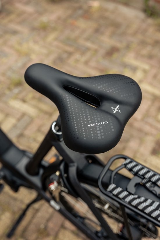 Zwart fietszadel met perforaties en het Voltano logo, op een fiets.