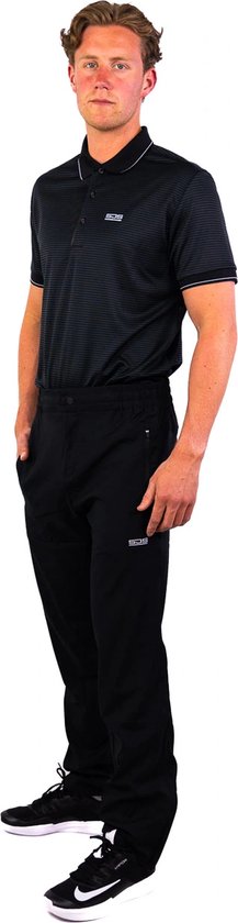 Man in een zwarte polo met fijne streep en zwarte trainingsbroek met ritszakken