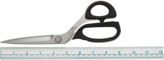 Metalen schaar met zwarte handgrepen, liggend op een liniaal met inches en centimeters.