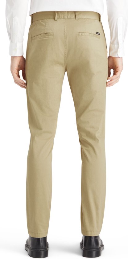 Achterkant van een beige chino gedragen door een man, met twee achterzakken en een logo-patch.