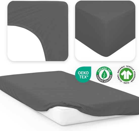 Donkergrijs hoeslaken op een matras. Close-up van de hoek toont het elastiek. OEKO-TEX en GOTS gecertificeerd.
