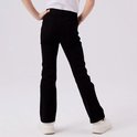 Meisje met de rug naar de camera, draagt een zwarte flared jeans en witte sneakers.