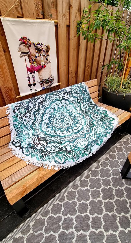 Rond kleed met groen-witte mandala print en franjes, op een houten bankje.