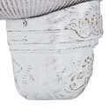 Close-up van de onderkant van een witte muurfontein met sierlijke, verweerde details.