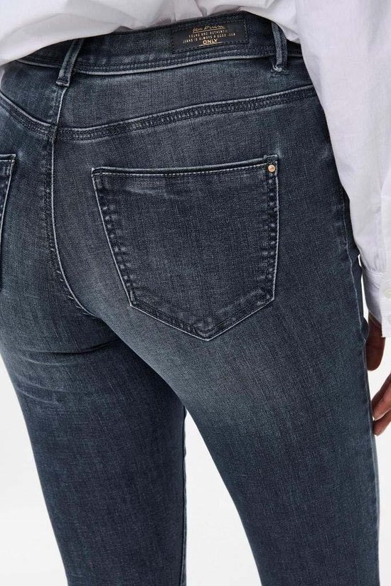 Donkerblauwe skinny jeans met een middelhoge taille, close-up van de achterkant met zakken.