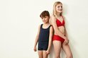 Jongen in donkerblauw singlet en jongen in rood ondergoed, staand naast elkaar.