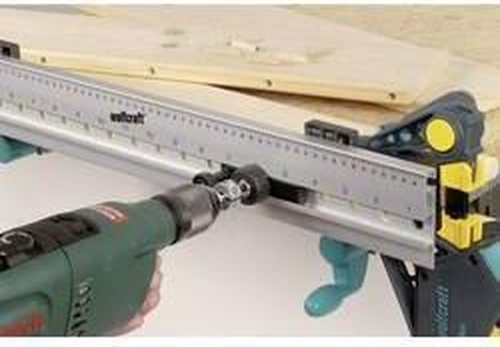 Wolfcraft geleiderail met boor en klemmen, in gebruik op een houten plank.
