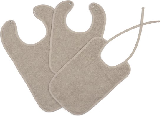 Drie zandkleurige slabben met textuur. Twee slabben sluiten met drukknoopjes, één met strikjes.