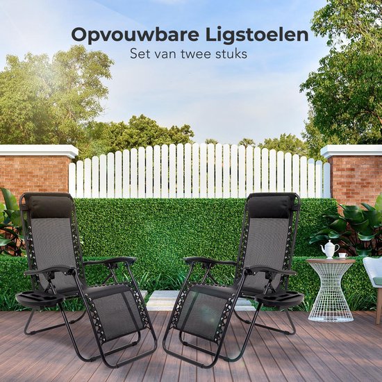 Twee zwarte, opvouwbare ligstoelen staan op een houten terras met een witte omheining op de achtergrond.