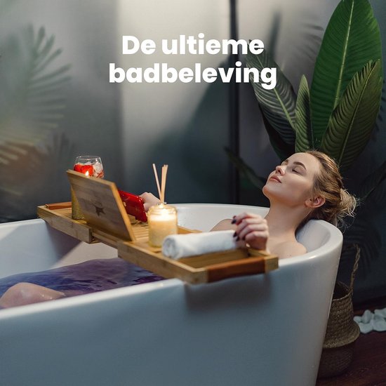 Vrouw ontspant in een bad met een bamboe badplank met tablet, kaars en handdoek.