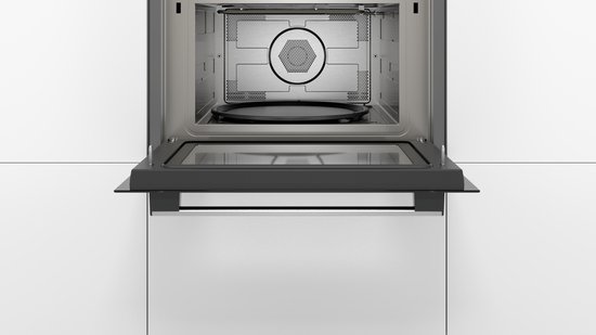Frontaal aanzicht van een open RVS combi-magnetron, interieur met draaitafel en rooster.