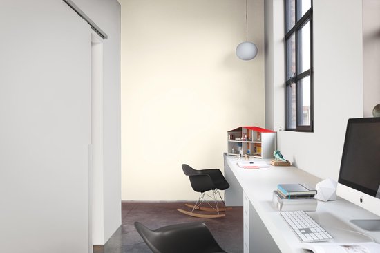 Kantoorruimte met wit bureau, computer, zwarte stoelen en een modelhuisje.