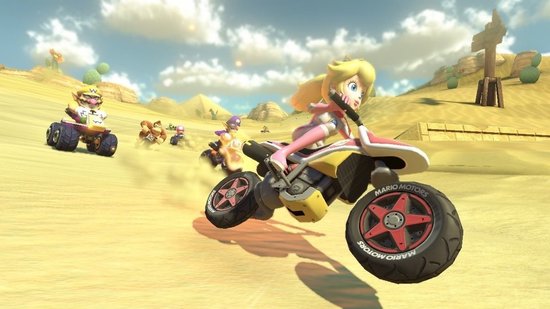 Prinses Peach racet op een motorfiets door een woestijnlandschap, met piramides op de achtergrond.