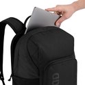 Hand legt een laptop in de zwarte rugzak.