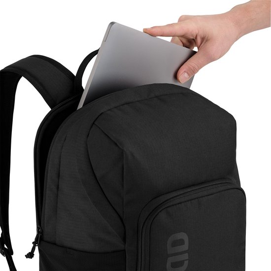 Hand legt een laptop in de zwarte rugzak.