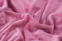 Roze fluwelen stof met kreukels.