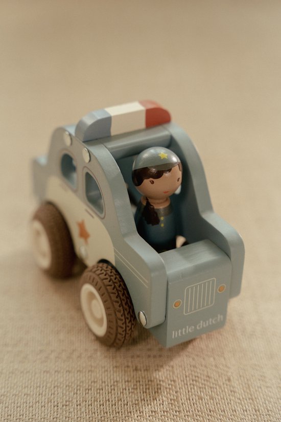 Houten politiewagen in het lichtblauw met een blauw-wit gestreept daklicht en een politiepoppetje met een ster op haar hoed. "little dutch" op de voorkant.