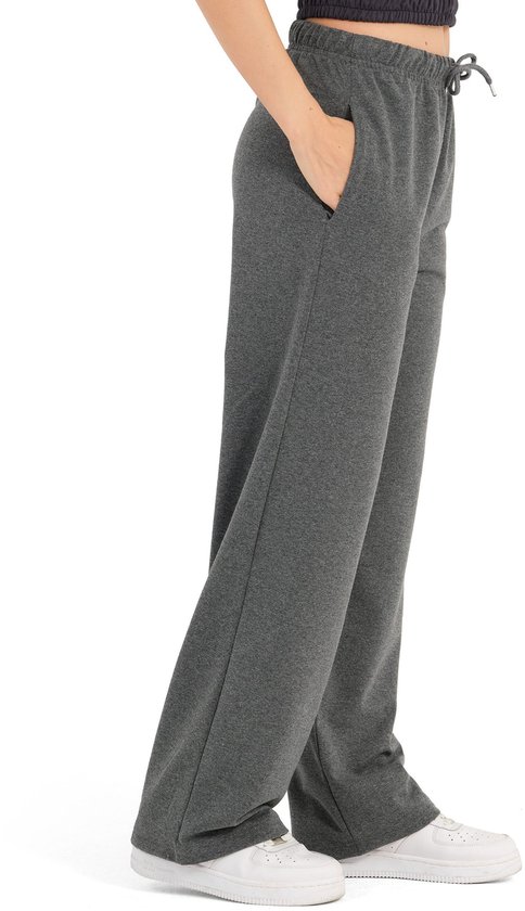 Detail van de wijde, antracietkleurige joggingbroek met koordje en zakken, gedragen door een model.
