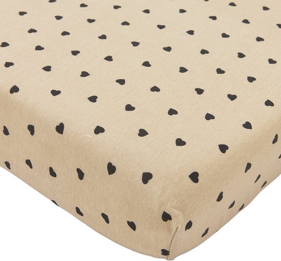 Beige hoeslaken met een patroon van kleine zwarte hartjes, close-up.