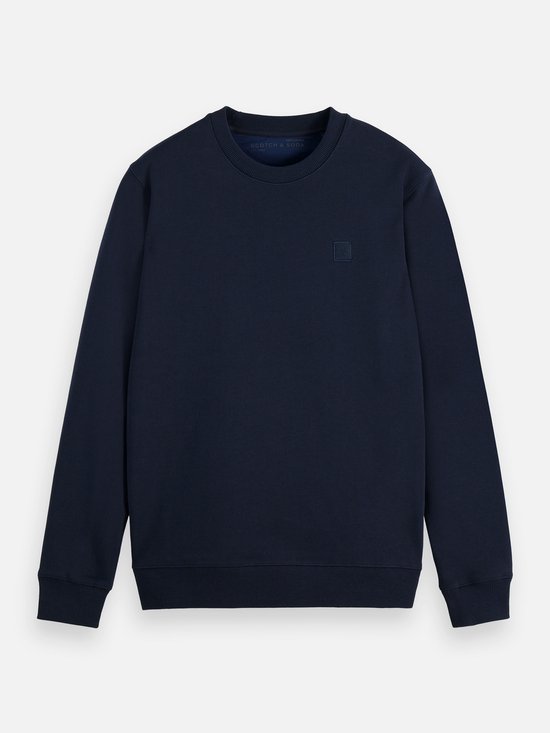 Donkerblauwe sweater met ronde hals. Het geborduurde vierkante logo op de borst is zichtbaar.