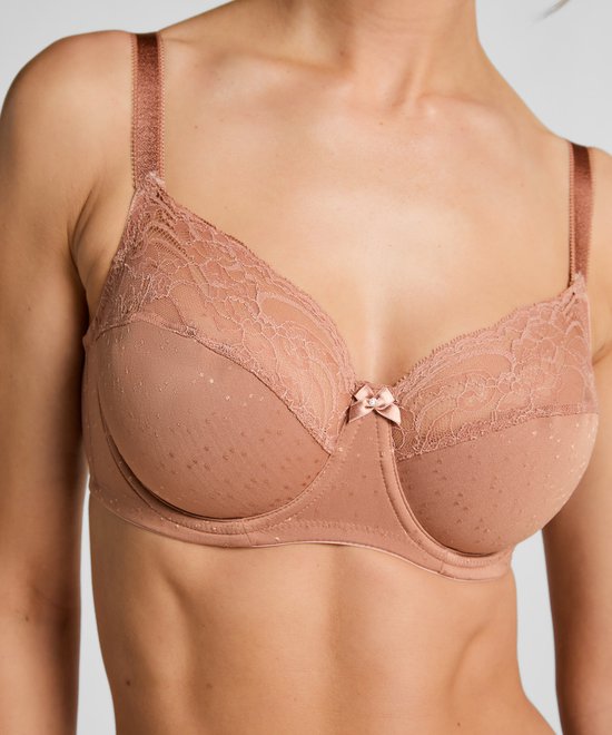 Close-up van een beige, niet-voorgevormde beugelbeha met stippen en kant.