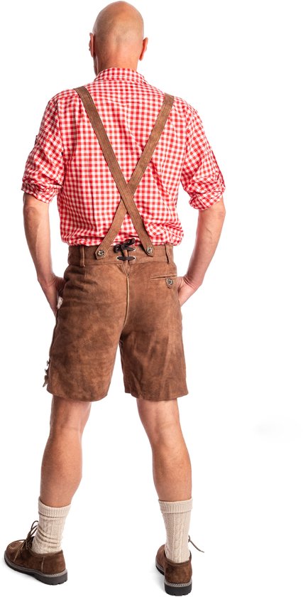 Man in traditionele bruine lederhosen met bretels, rood-wit geruite blouse en beige sokken.