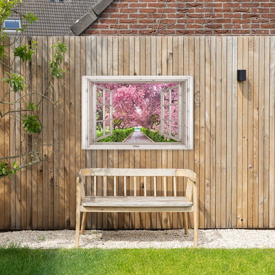 Een schilderij van een open raam met uitzicht op een pad omringd door bloeiende kersenbomen, opgehangen aan een houten schutting boven een bankje.