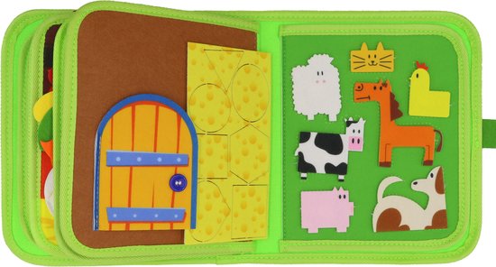 Groen stoffen boek met boerderijthema. Links: bruine deur met gele cirkels op geruite achtergrond. Rechts: stoffen boerderijdieren: kat, schaap, paard, koe, varken, hond, kip.