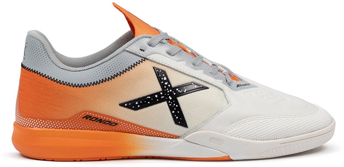 Futuristische grijze indoor voetbalschoenen met oranje accenten, zachte PU en gestructureerde teen voor betere grip.