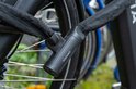 Detail van het zwarte Voltano kettingslot om een fietswiel.